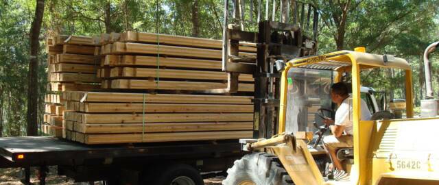 5000 lbs. all terrain forklift unloading logs forklift